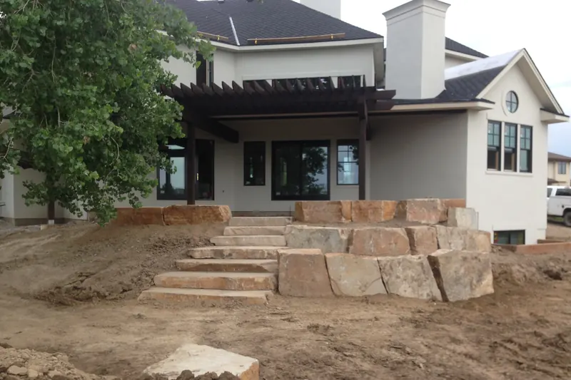 Boulder steps and retaining wall built behind a new home