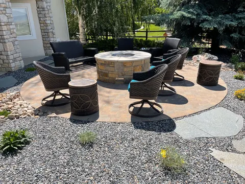 Round stamped patio with a stone fire pit and swivel chairs in Fort Collins.